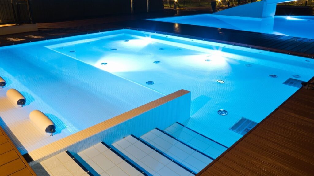 Add some luxury to your small pool with lighting, water features, and decking