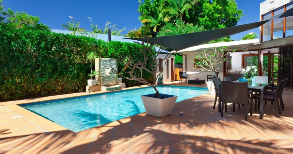 Get ready to relax in your backyard oasis with these tropical pool landscaping ideas.